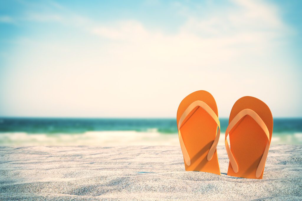 Orange flip flops sticking out of sand on beautiful beach background. Vacation and lifestyle concept. 3D Rendering