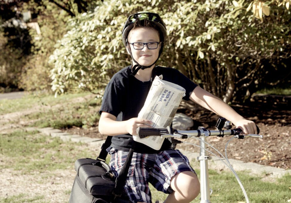 Newspaper delivery boy on his bicycle